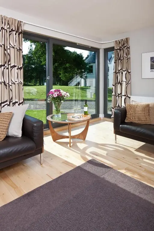 a living room with a couch and a table at Bright, contemporary house & large private garden in Strathpeffer