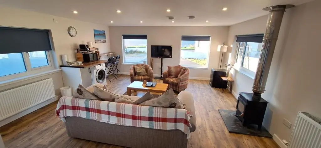 a living room with a couch and chairs and a tv at CeolMara in Ullapool