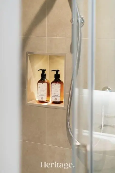 two bottles of soap on a shelf in a shower at Blythewood Aberdeenshire Luxury Lodge with Hot Tub in Kemnay