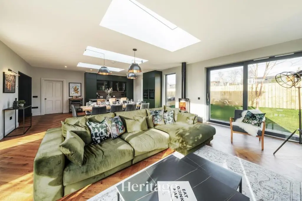 a living room with a green couch and a kitchen at Blythewood Aberdeenshire Luxury Lodge with Hot Tub in Kemnay