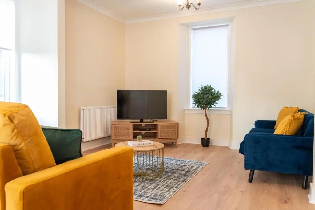 a living room with a couch and a tv at Rosewood Cottage in Cornhill
