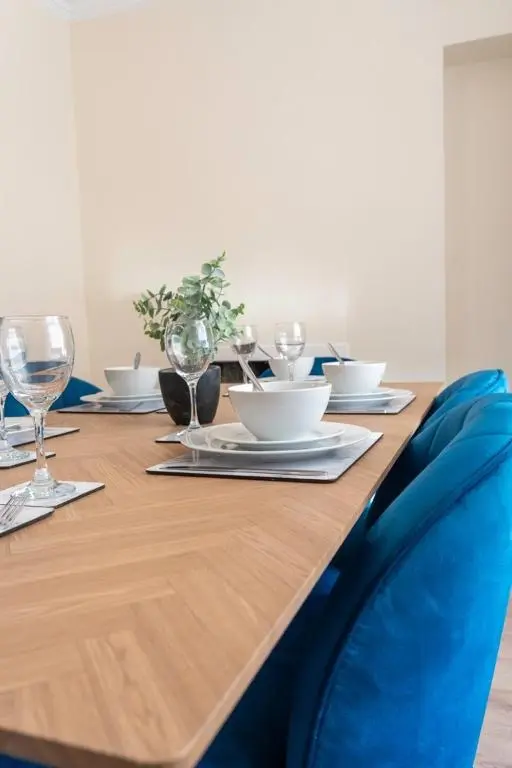 a wooden table with plates and wine glasses on it at Rosewood Cottage in Cornhill