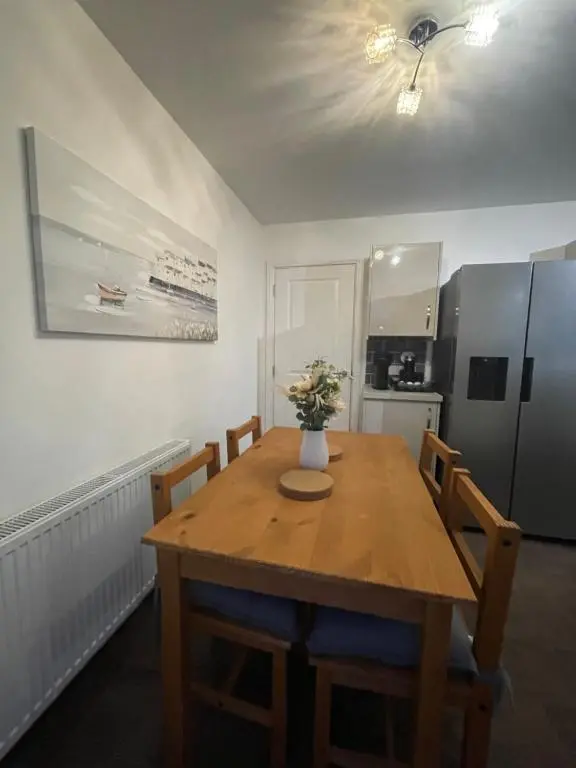 a kitchen with a wooden table with chairs and a refrigerator at Inverness Retreat in Inverness