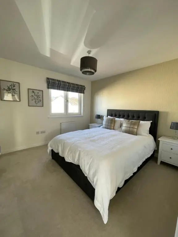 a bedroom with a large white bed with a window at Inverness Retreat in Inverness