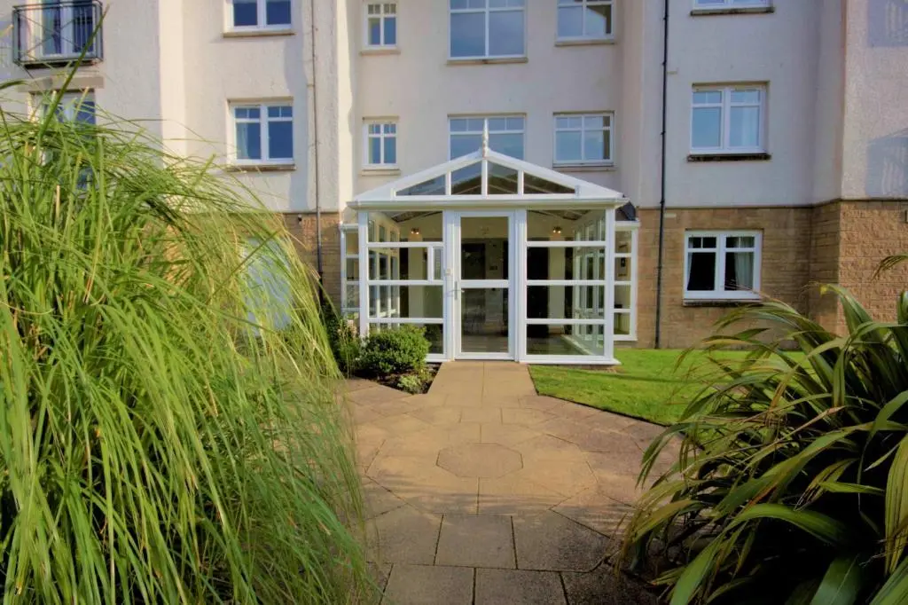 an external view of a building with a conservatory at No10 The Links Apartment, Brora in Brora
