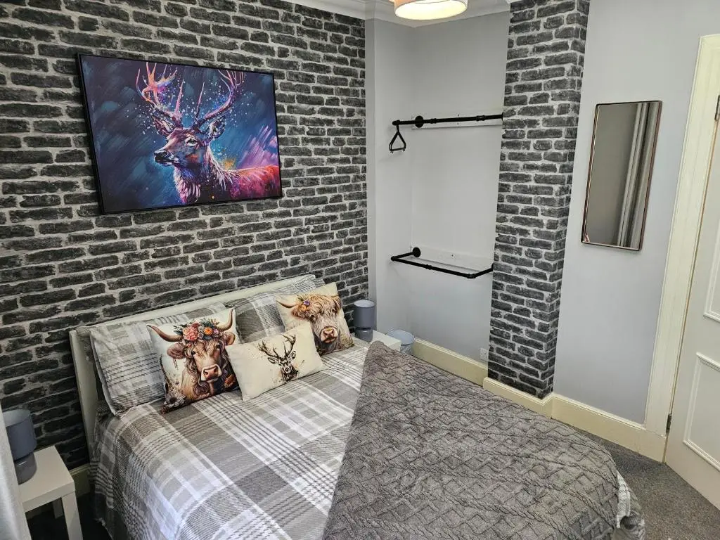 a bedroom with a bed and a brick wall at Cosy highland getaway in Grantown on Spey