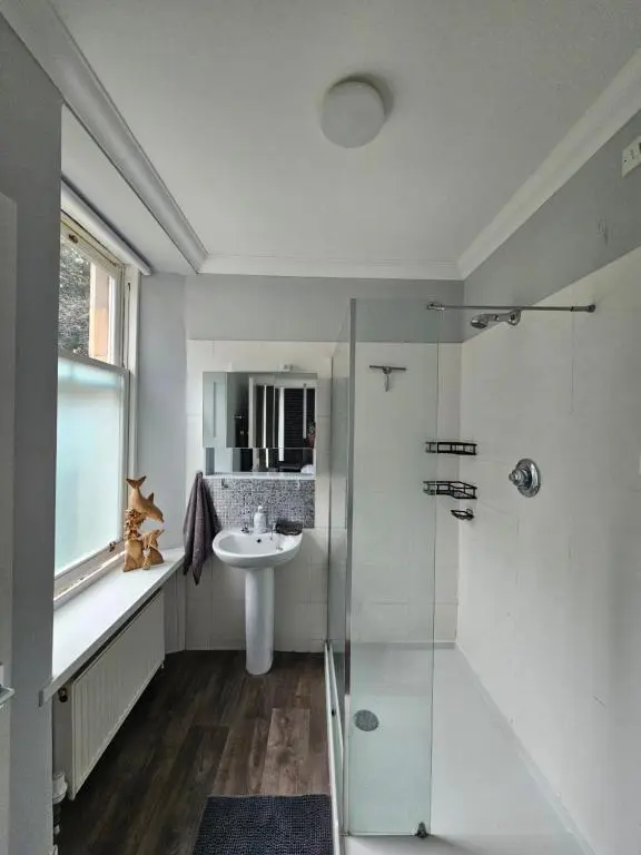 a bathroom with a sink and a glass shower at Cosy highland getaway in Grantown on Spey