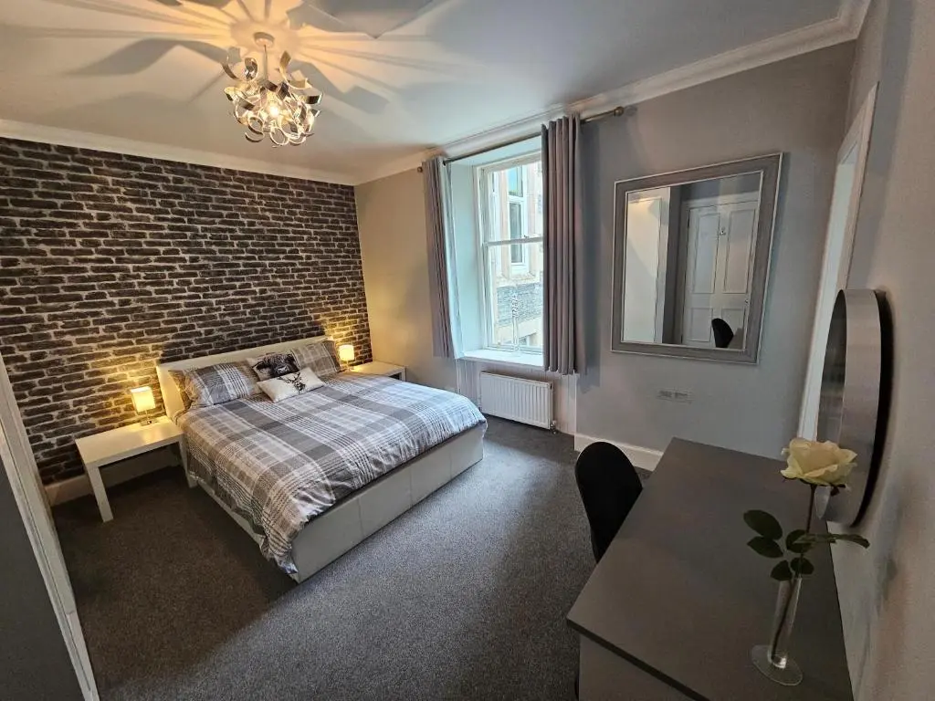 a bedroom with a bed and a brick wall at Cosy highland getaway in Grantown on Spey