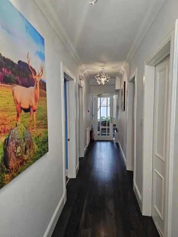 a hallway with a painting of a deer on the wall at Cosy highland getaway in Grantown on Spey