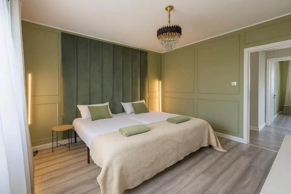 a bedroom with a large white bed with green walls at Cosy Laurel Nest Near Loch Ness in Inverness