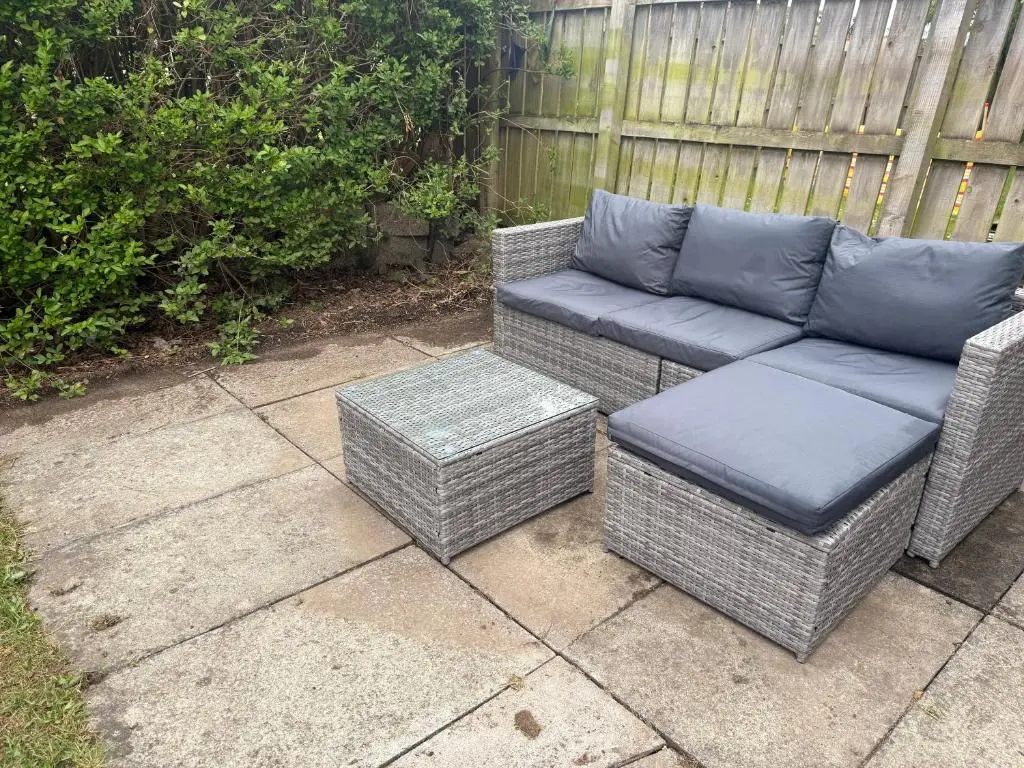 two wicker chairs and a couch on a patio at Cosy Laurel Nest Near Loch Ness in Inverness