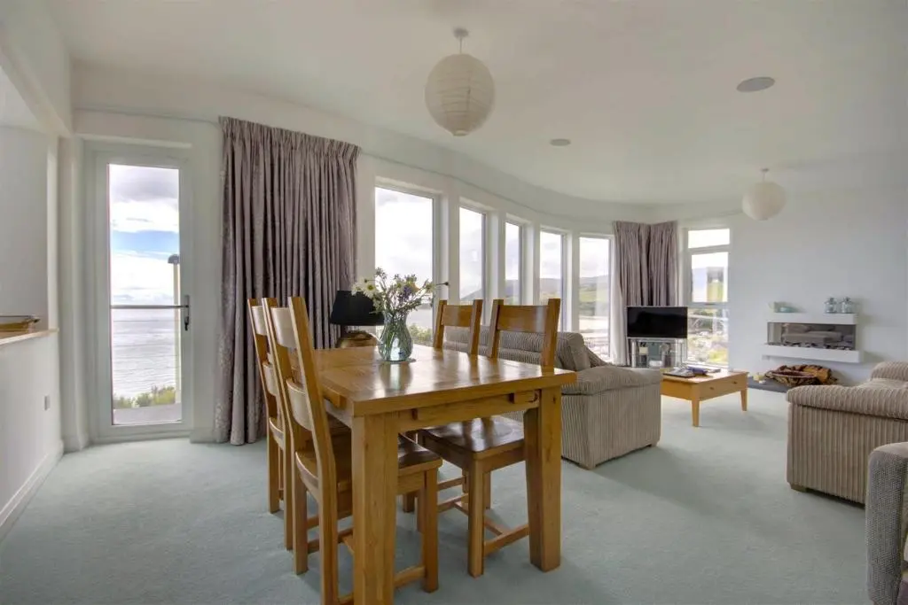 a living room with a dining room table with chairs at The Old Coastguard Station in Helmsdale