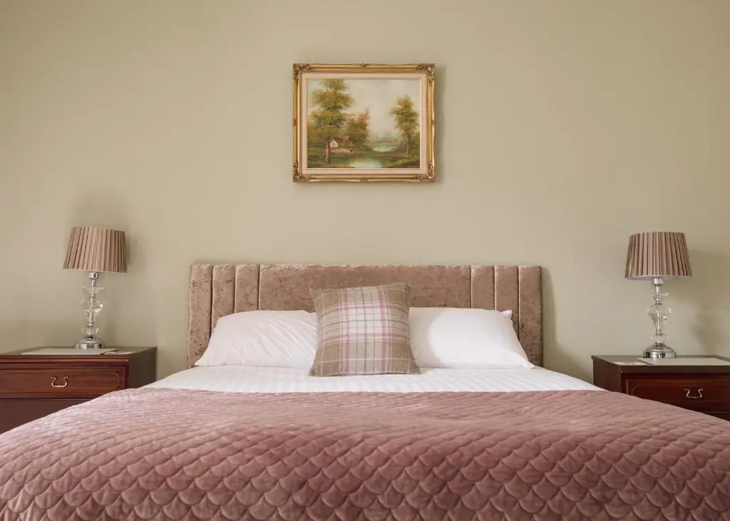 a bedroom with a bed with a picture on the wall at Estate Of Ord in Muir of Ord