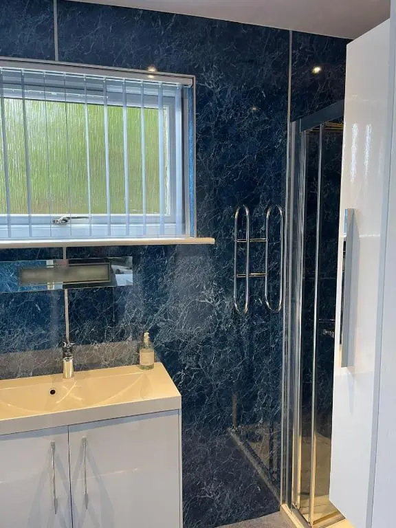 a bathroom with a sink and a glass shower at Runnymede House in Inverness