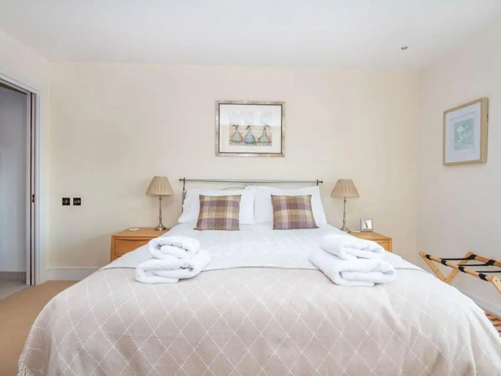 a bedroom with a large bed with towels on it at 2 Bedroom Riverside Apartment 301-Free Parking in Inverness