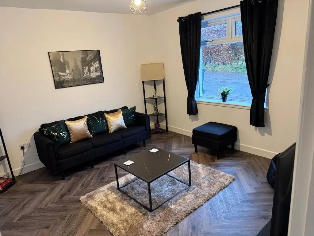 a living room with a couch and a table at Lorna Doune in Port Elphinstone