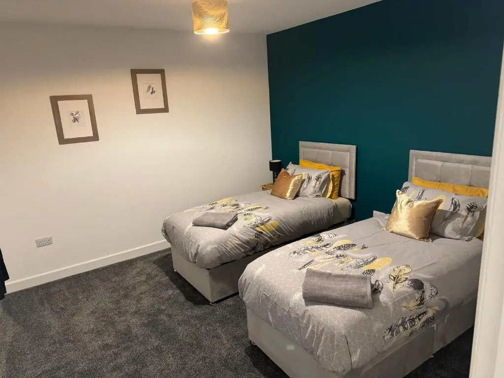 a bedroom with two beds and a green wall at Lorna Doune in Port Elphinstone