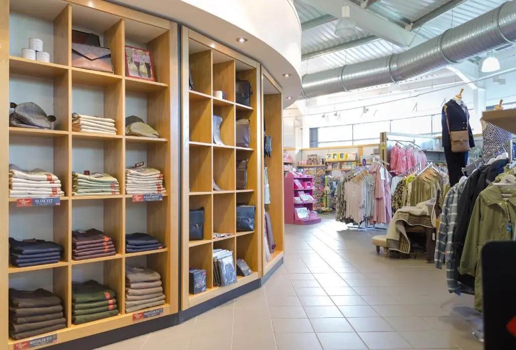 a store aisle with shelves of clothes in a store at Macdonald Morlich Hotel at Macdonald Aviemore Resort in Aviemore