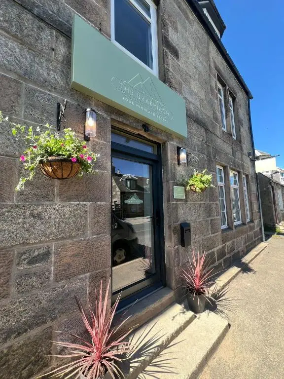 a brick building with plants in front of a window at The Braeriach in Newtonmore