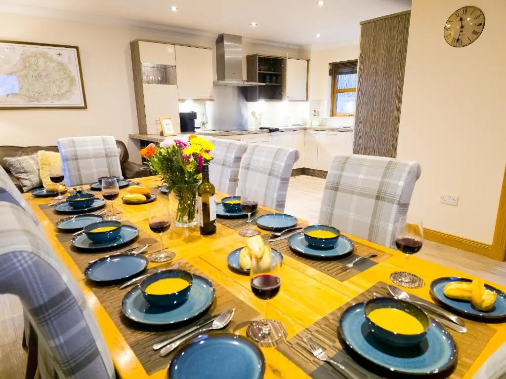 a dining room table with blue and yellow dishes on it at Lairig Ghru Lodge in Aviemore