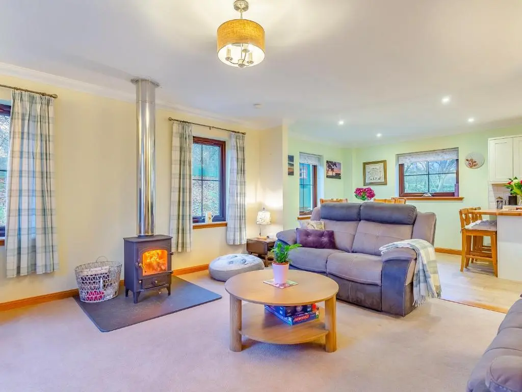 a living room with a couch and a stove at Bunchrew Farm Cottage in Inverness