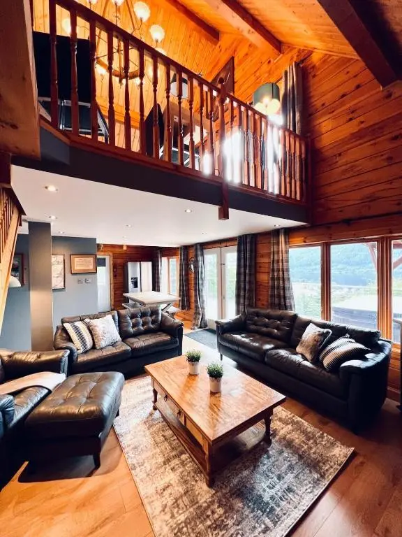 a large living room with couches and a table at Lodges On Loch Ness in Inverness