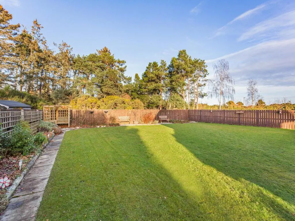 a backyard with a fence and a grass yard at Rock Folly in Inverness