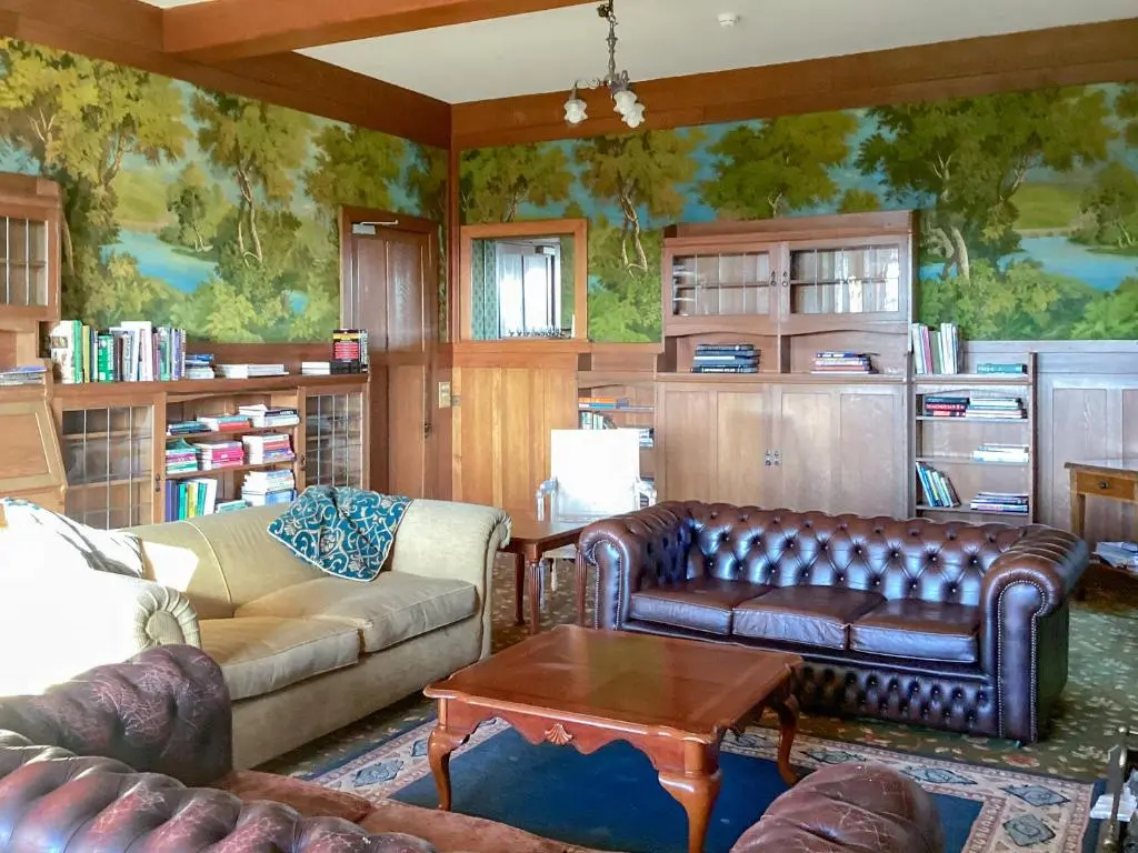 a living room with couches and a painting on the wall at The Carnegie Rooms At Aultnagar Lodge - Uk48666 in Lairg