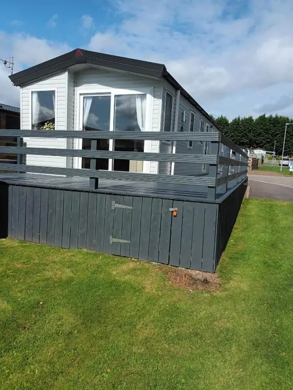 a small house with a porch on the grass at Lynmar retreat No 35 in Dornoch