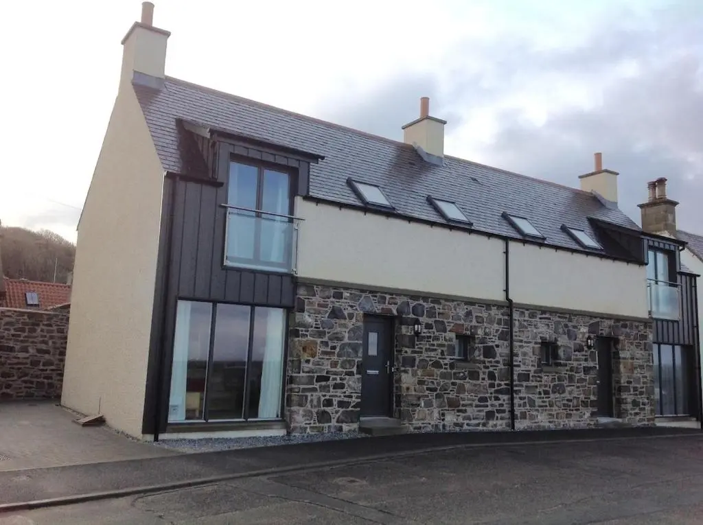 a brick building with windows and a black roof at 244 Seatown Cullen Moray Scotland in Cullen
