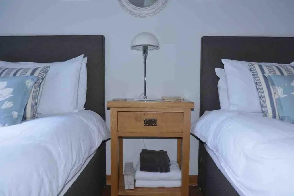 abedroom with two beds and a night stand with a lamp at 244 Seatown Cullen Moray Scotland in Cullen