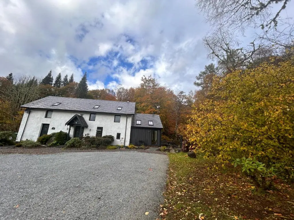 a white house in the middle of a road at Aldernaig Mill in Invergarry