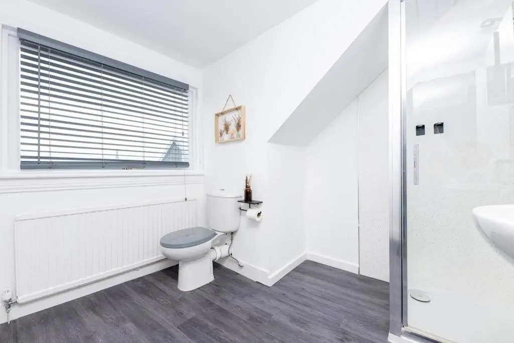 a white bathroom with a toilet and a sink at Ness Heights in Inverness