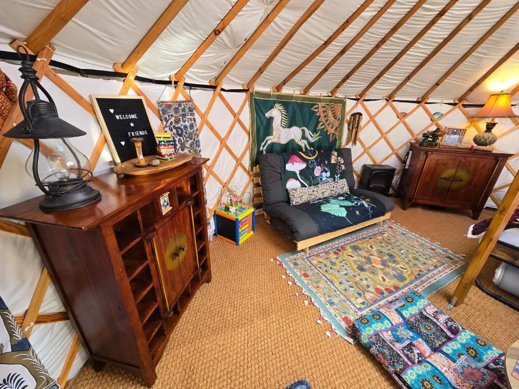 a room with a chair and a desk in a yurt at Rainbow's End Yurts in Dornoch