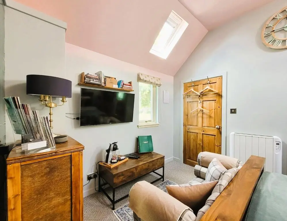 a living room with a couch and a tv at Bespoke Luxury Self Catering Dog Friendly Accommodation in Archiestown