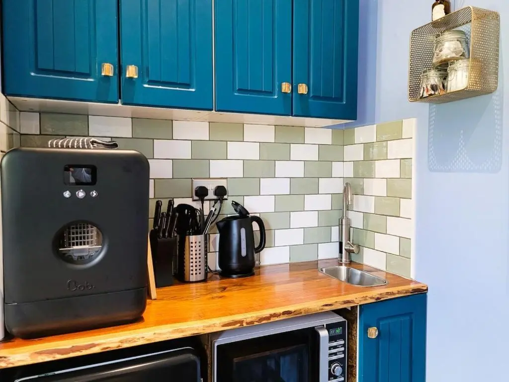 a kitchen counter with blue cabinets and a sink at Bespoke Luxury Self Catering Dog Friendly Accommodation in Archiestown