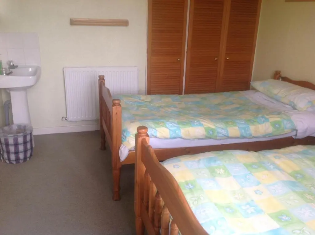 a room with three beds and a sink and a sink at Fraoch Lodge in Boat of Garten