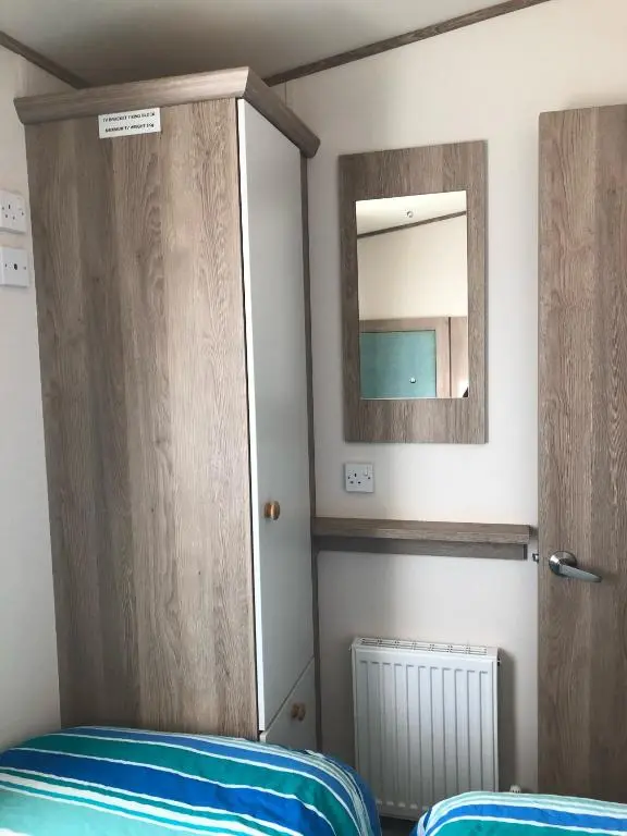 a bedroom with a mirror and a bed and a closet at Ballies Retreat in Lossiemouth