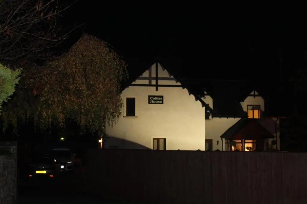 a white house at night with a car in front at Culliss House B&B in Inverness