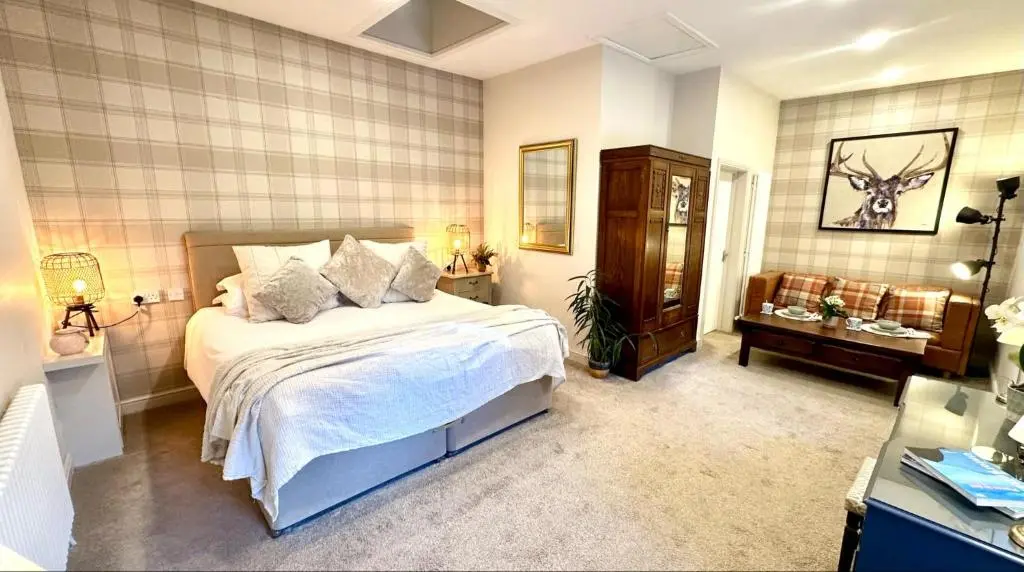a bedroom with a bed and a dresser in it at Beechtree Cottage, Cairngorm Suite, Kirkmichael in Blairgowrie