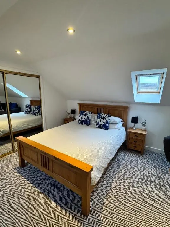 a bedroom with a bed and a large mirror at An Cuiltheann Apartment in Turriff