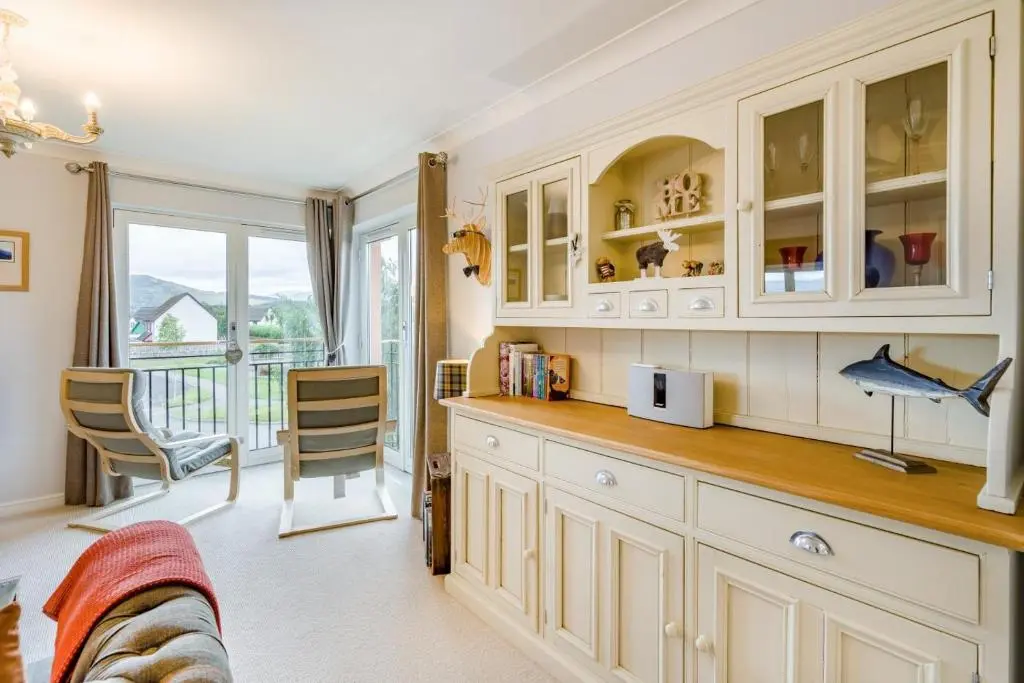 a kitchen with white cabinets and a table and chairs at 2 Bed in Aviemore oc-t30584 in Aviemore