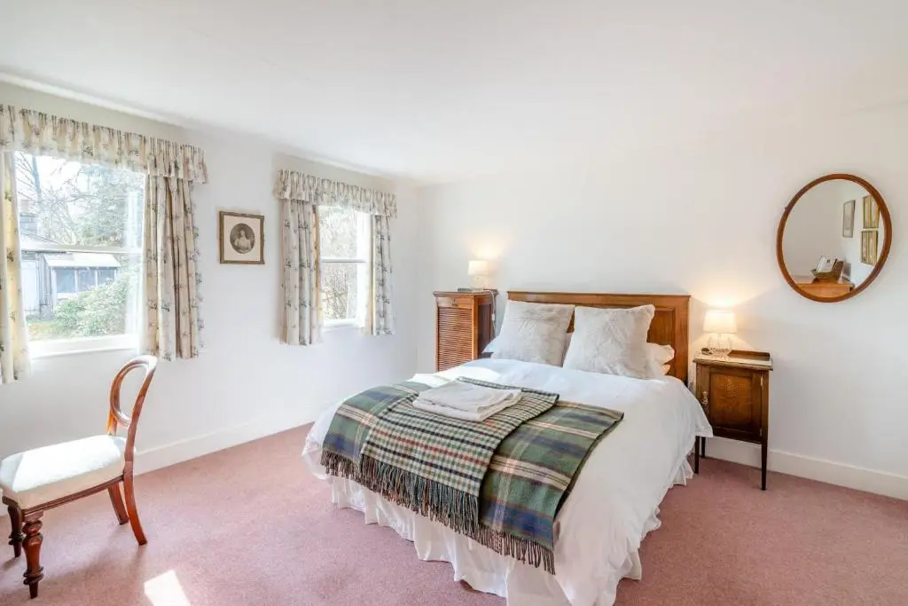 a bedroom with a bed and a mirror and a chair at 7 Bed in Strathdon oc-t30594 in Strathdon