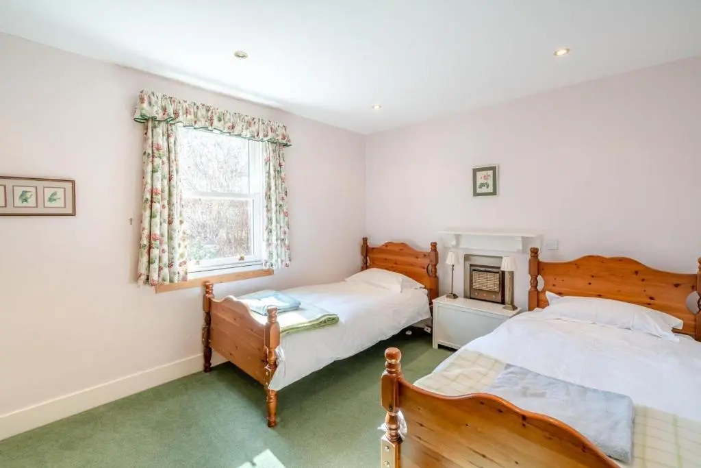 a bedroom with two beds and a fireplace at 7 Bed in Strathdon oc-t30594 in Strathdon