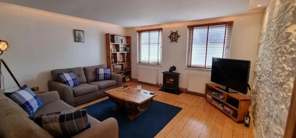 a living room with a couch and a tv at Beautiful 3 bedroom house short walk from the beach in Nairn