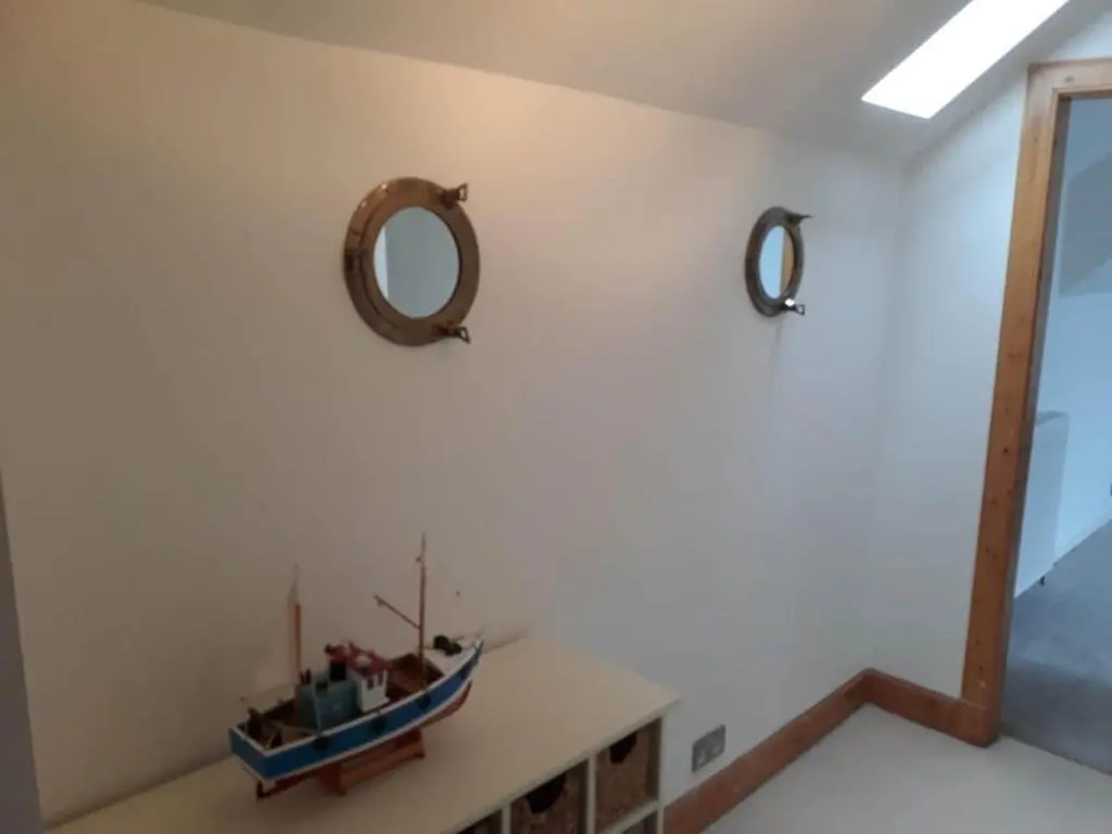 a room with a table with a boat on a wall at Beautiful 3 bedroom house short walk from the beach in Nairn