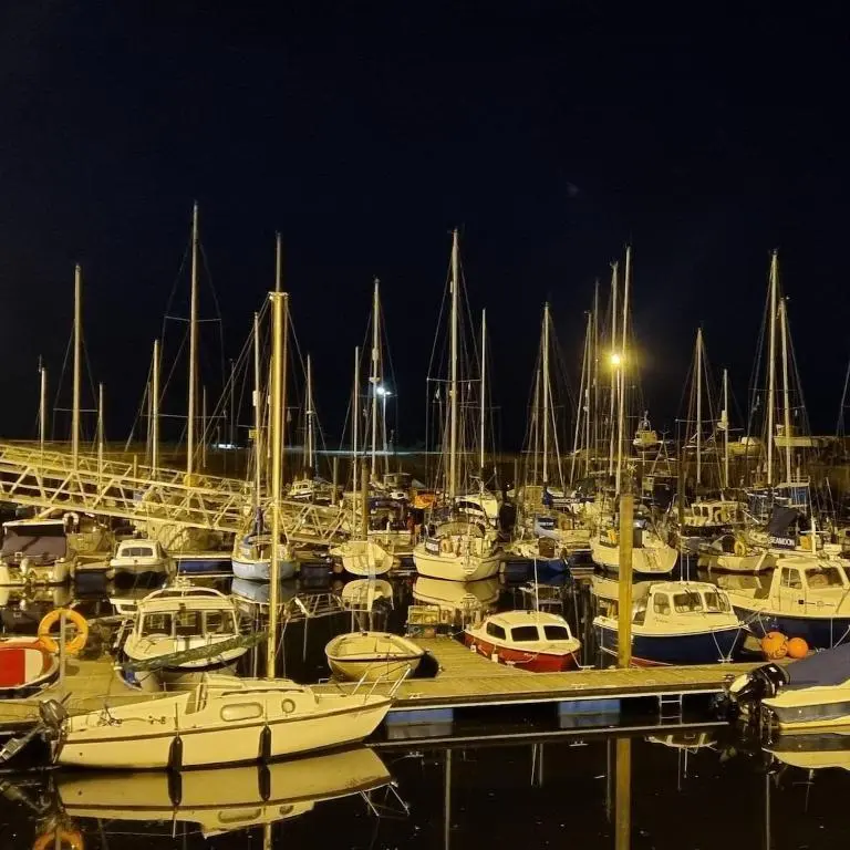 a bunch of boats docked in a marina at night at Beautiful 3 bedroom house short walk from the beach in Nairn