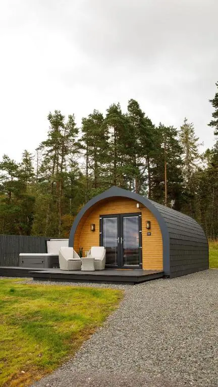 a small house with a yellow and gray roof at Shin View Pods in Lairg