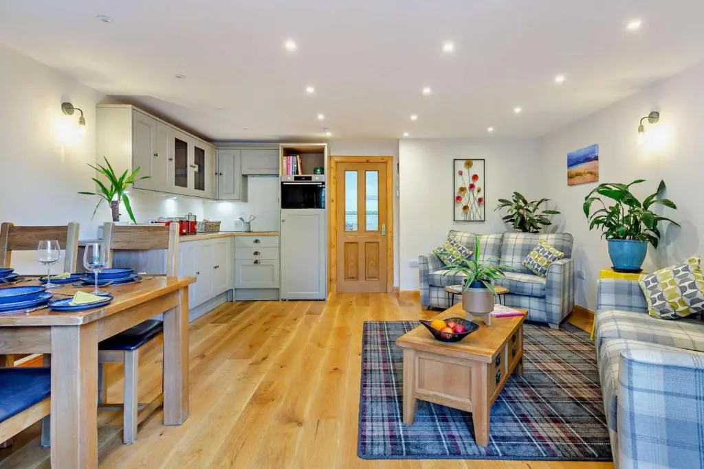 a living room with a table and a kitchen at 1 Bed in Strathpeffer oc-h30077 in Strathpeffer