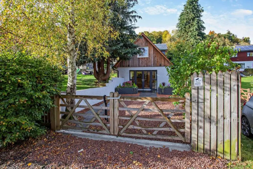 a wooden fence in front of a house at 1 Bed in Strathpeffer oc-h30077 in Strathpeffer